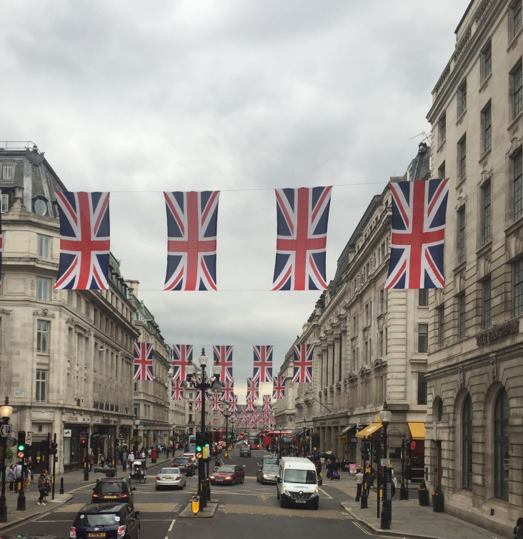 Union Jacks fly between buildings over the streets in Piccadilly Circus