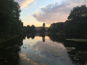 Sun sets over a pond in Saint James park in front of Buckingham Palace