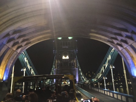 A tour bus passes under a tunnel on the London Bridge