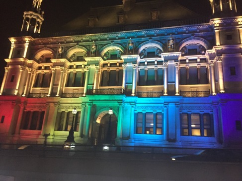 The front of a building in London lit in rainbow colors