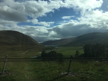 A river leading to a loch between rolling hills