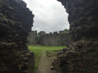 The courtyard of Inverlochy Castle through a crumbling doorway