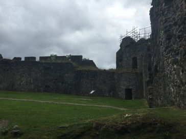 A corner of the courtyard of Inverlochy castle where a tower is surrounded by scaffolding during repairs
