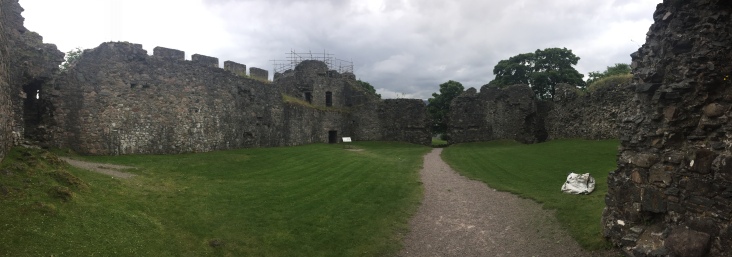 The courtyard of Inverlochy Castle surrounded by crumbling walls and towers