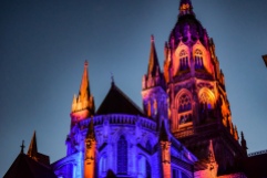 The Bayeux Cathedral lit in orange and purple at dusk
