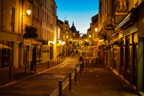 Streetlights and shops line the main pedestrian avenue running through the old town in Bayeux
